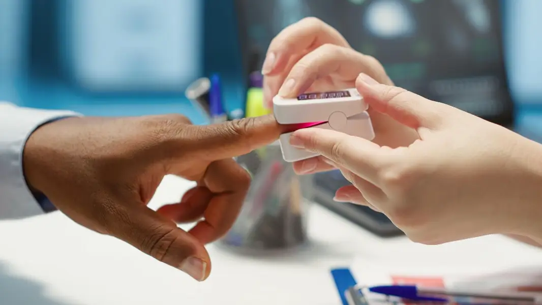 Physician measuring the oxygen saturation and pulse rate using an oximeter